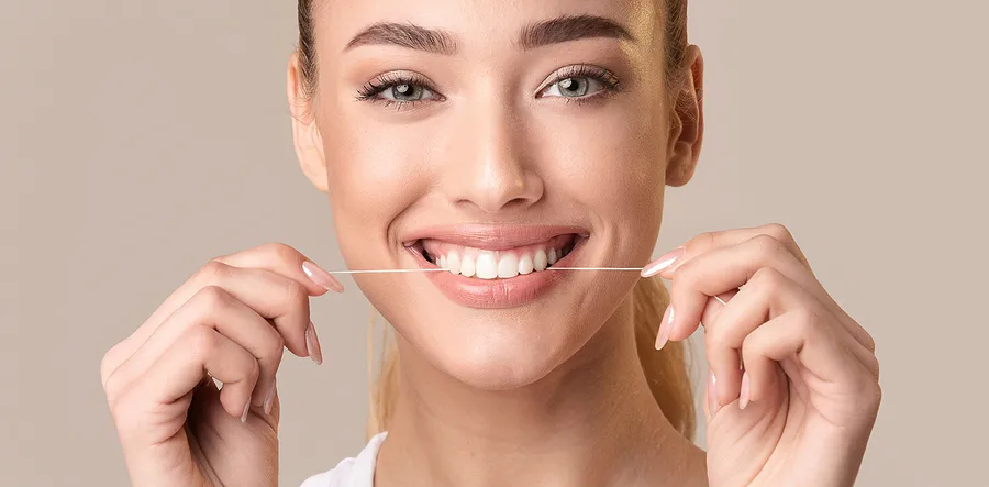 How does flossing prevent plaque build-up?